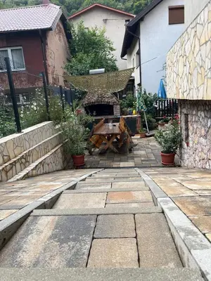 a patio with a table and a hammock in a yard at Apartman Omerovic - Panon Centar Tuzla in Tuzla