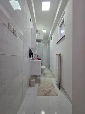 a white bathroom with a toilet and a sink at Apartman Omerovic - Panon Centar Tuzla in Tuzla
