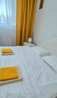 a white bed with two towels on top of it at Apartman Stanković in Teslić