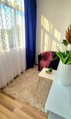 a living room with a couch and a table with a vase of flowers at Apartman Stanković in Teslić