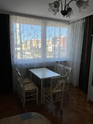 a dining room with a table and chairs and a window at Apartman Lavanda in Živinice
