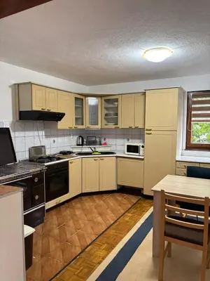 a kitchen with white cabinets and a table in it at Apartman Kahvica in Travnik