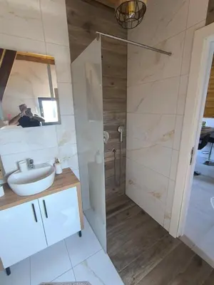 a bathroom with a shower and a sink and a mirror at Atrijland Cazin in Cazin