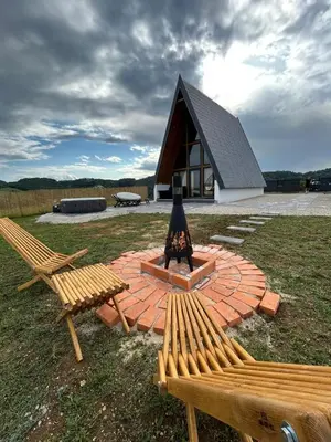 a fire pit with two benches in front of a building at Atrijland Cazin in Cazin