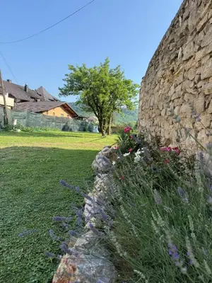 a stone wall with flowers in a yard at Royal Luxury Apartment in Bihać