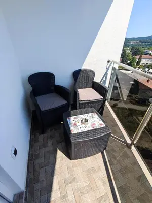 two chairs and a table on a balcony at Apartman Maja 46 in Doboj