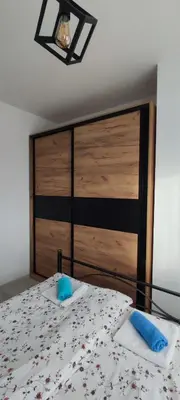 a bedroom with a bed with a wooden head board at Apartman Maja 46 in Doboj