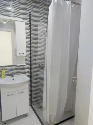 a bathroom with a shower curtain and a sink at Apartman Maja 46 in Doboj