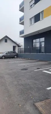 a car parked in a parking lot next to a building at Apartman Maja 46 in Doboj