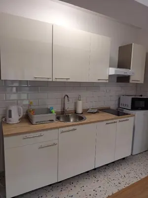 a kitchen with white cabinets and a sink at Apartmani Piralis in Bihać