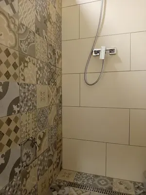 a shower with a shower head in a bathroom at Apartmani Piralis in Bihać