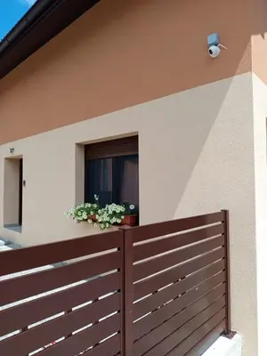 a house with a wooden fence and a window at Apartmani Piralis in Bihać
