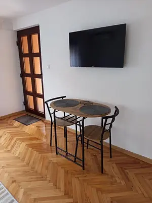 a table with two chairs and a television on a wall at Apartmani Piralis in Bihać