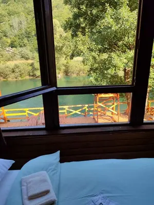 a bedroom with a view of a river from a window at Plivski raj in Jezero