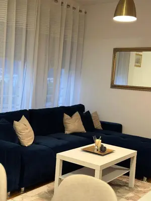 a living room with a blue couch and a table at Apartman Radmanović in Banja Luka