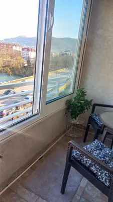 a room with two windows and a table and a chair at Venecija Most in Banja Luka