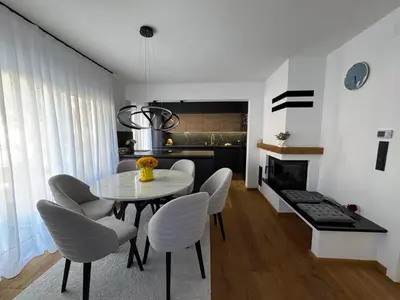 a dining room with a table and white chairs at Una-Luxury-suite in Bihać