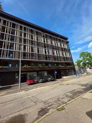 a large building with cars parked in front of it at Apartman RS Palata in Banja Luka