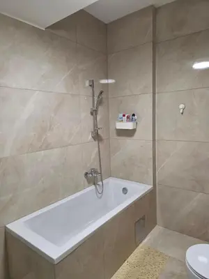 a bathroom with a shower with a tub and a toilet at Apartman RS Palata in Banja Luka