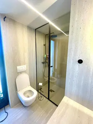 a bathroom with a toilet and a glass shower at Villa Evora in Banja Luka