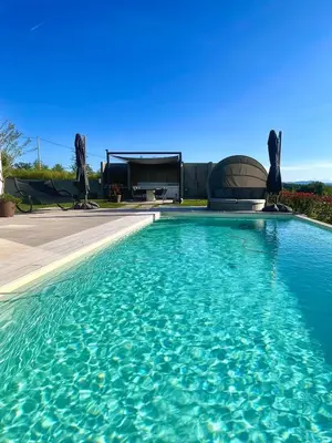 a swimming pool with blue water in front of a house at Villa Evora in Banja Luka