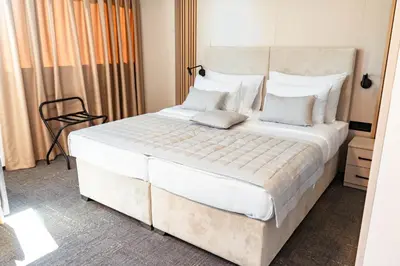 a bedroom with a large bed with white sheets and pillows at Hotel Branch in Doboj