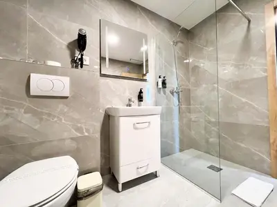 a bathroom with a toilet and a sink and a shower at Hotel Branch in Doboj