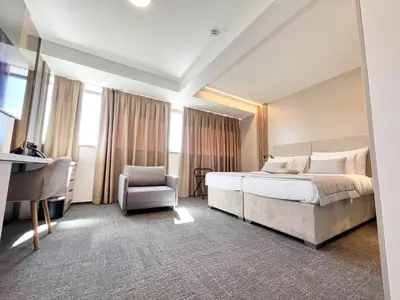 a hotel room with a bed and a chair at Hotel Branch in Doboj