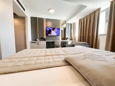 a bedroom with a large bed with a tv on the wall at Hotel Branch in Doboj
