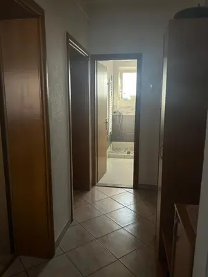 a hallway of a bathroom with a shower and a door at Apartman Iris in Bosanski Brod