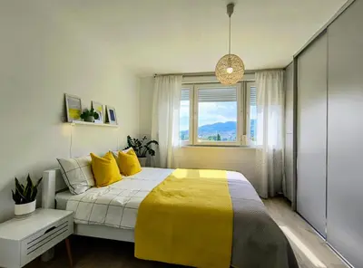 a bedroom with a yellow and white bed with a window at Sunflower Apartment in Banja Luka