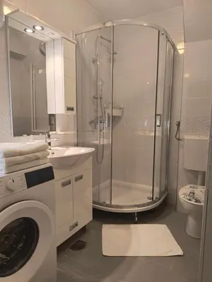 a bathroom with a shower and a washing machine at Sunflower Apartment in Banja Luka