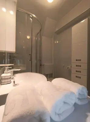 a bathroom with a tub and a sink and towels at Sunflower Apartment in Banja Luka