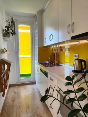 a kitchen with white cabinets and a sink and a window at Sunflower Apartment in Banja Luka