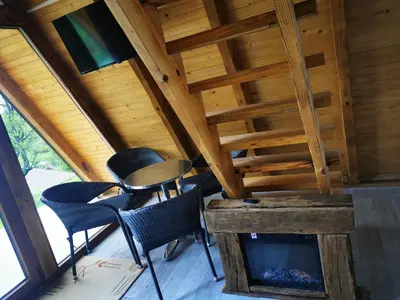 a room with chairs and a table and a fireplace at Naša Maša Doboj- bungalov Nasa Masa Doboj-bungalov in Doboj