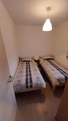 two beds in a small room with a lamp at Majestic House in Ivišovo Greblje