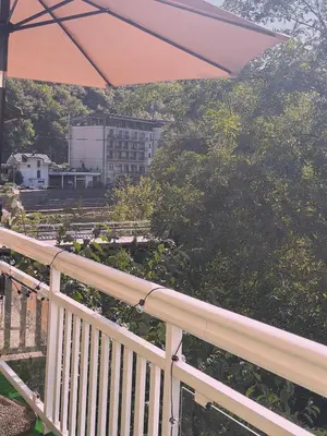 a white railing with an umbrella on a balcony at Layal Home in Bihać