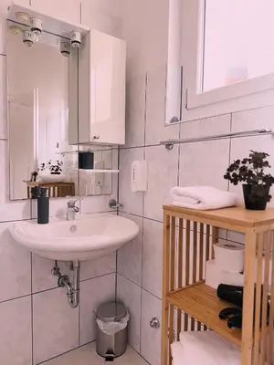 a white bathroom with a sink and a mirror at Layal Home in Bihać