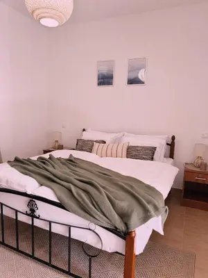 two beds in a room with white walls at Layal Home in Bihać