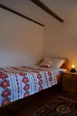 a bedroom with a bed with a red and white blanket at Ranč Kuzmanović in Doboj