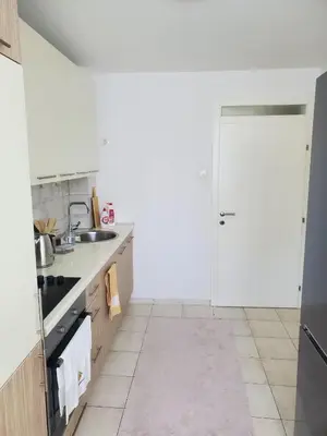 a white kitchen with a sink and a door at StaraCarsija- Zenica, City Center in Zenica