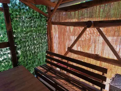 a room with a thatched roof with a wooden bench at Retro II