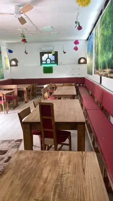 a dining room with wooden tables and red benches at Retro II