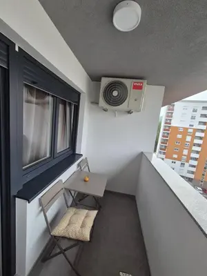 a balcony with a table and a window and a speaker at Apartman Belvedere Lux, Doboj in Doboj