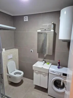 a bathroom with a toilet and a washing machine at Apartman Belvedere Lux, Doboj in Doboj