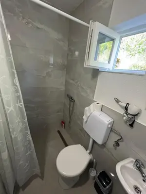 a bathroom with a toilet and a sink and a window at Apartment Amila in Jajce