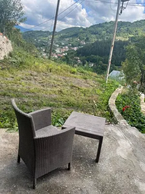a wicker chair and table sitting on top of a hill at Apartment Amila in Jajce
