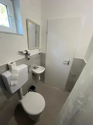 a white bathroom with a toilet and a sink at Apartment Amila in Jajce