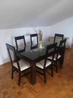 a black table with four chairs and a vase on it at Apartment Nedic in Doboj