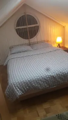 a large bed in a room with a lamp at Apartment Nedic in Doboj